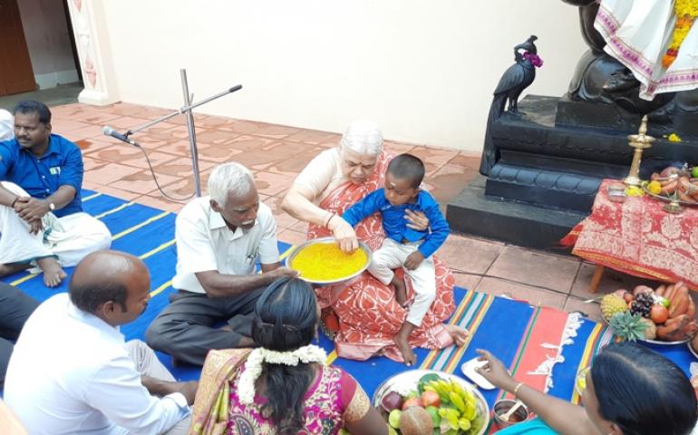 Mann. Rekha Didi holding the right index finger of a child and make him write ‘Om’ on the fistful of rice placed in a large plate.